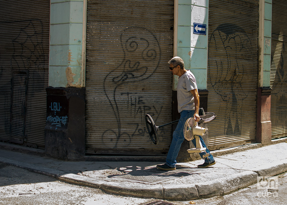 Un hombre traslada ventiladores para reparar en La Habana, en el verano de 2024. Foto: Otmaro Rodríguez.