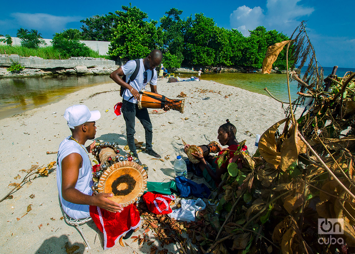 Jóvenes preparan tambor batá para una ceremonia religiosa en la playa de  Bacuranao , La Habana del Este. Foto: Otmaro Rodríguez.