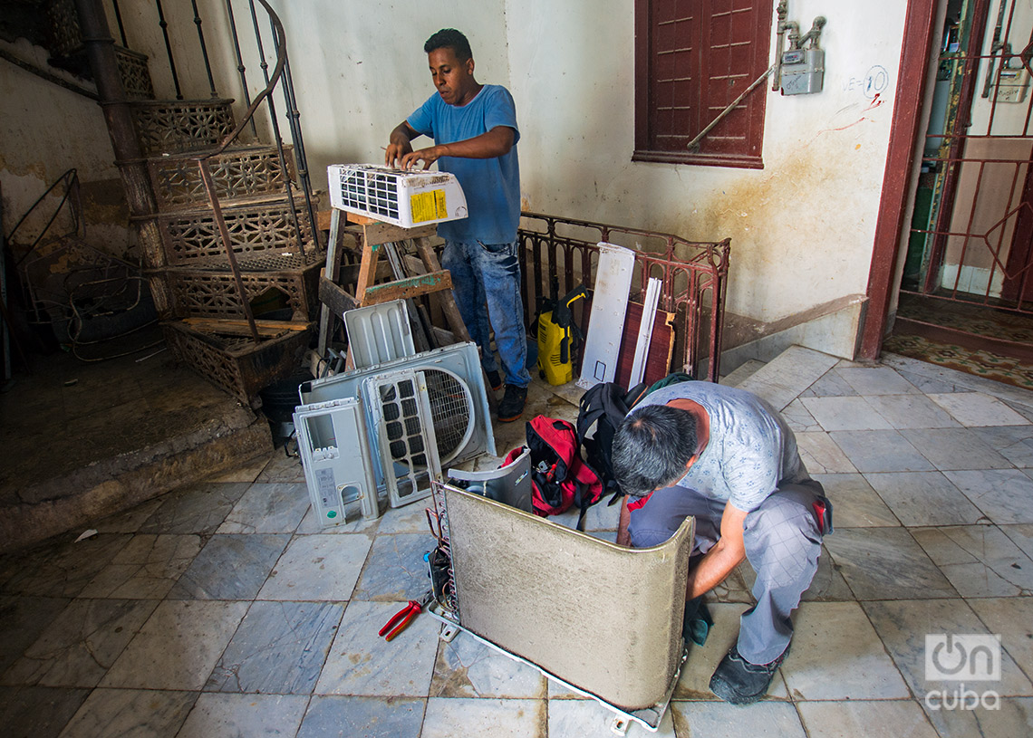 Técnicos reparando aire acondicionado en el verano de 2024. Foto: Otmaro Rodríguez.